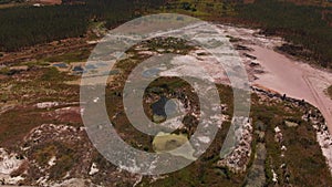 Aerial of of opencast mining quarry with ponds