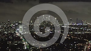 AERIAL: Over Dark Hollywood Los Angeles at Night with Clouds over Downtown and City Lights