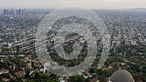 AERIAL: Over Griffith Observatory with Los Angeles, California Skyline in background in Daylight,Cloudy