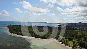 Aerial Over Tropical Secluded Beach With High Rise Hotels in Distance