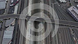 AERIAL: Overhead , Birds Eye View on Los Angeles River with Water on Cloudy Overcast Sky next to Train Tracks