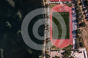 Aerial overhead drone shot of football field by Ionian sea in Argostolion, on Kefalonia Island