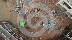 Aerial overhead moving up view of an excavator and dump truck.