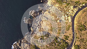 Aerial overhead a rocky coastline with dramatic road