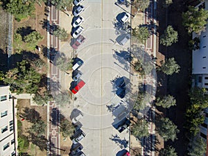 Aerial overhead shot of a cars parked along a street with a red brick sidewalk and lush green trees and buildings in Pasadena