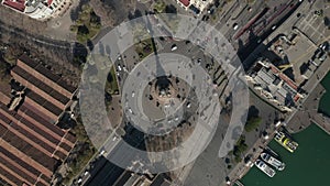 AERIAL: Overhead Shot of Columbus Monument Roundabout in Barcelona, Spain with Busy Car traffic on Sunny Day