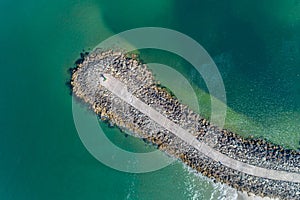 Aerial overhead view of a groyne on a beach, breakwater for coastal and harbour protection