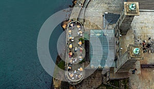 Aerial overhead view of people and tourists sitting on the terrace of a bar on the Porto seafront and buskers from the Dom Luis