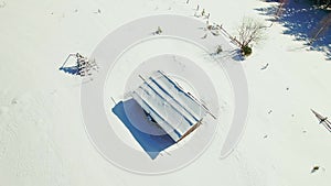 Aerial overhead view Snow covered clearing in the forest. Barn in the winter field.