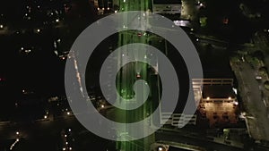 AERIAL: Overhead View of Street at Night with Store Parking Lot and City Car Traffic Lights