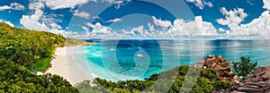 Aerial Pano of Grand Anse beach at La Digue island in Seychelles. White sandy beach with blue ocean lagoon and catamaran