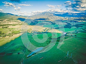 Aerial panorama of agricultural fields, meadows, and pastures at sunset.