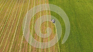 Aerial panorama of agricultural land, a combine is working below.