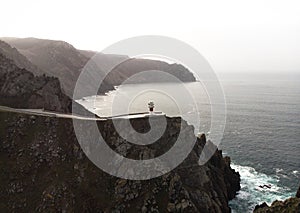 Aerial panorama of Cabo Ortegal lighthouse on steep rocky cliff atlantic ocean bay of biscay Carino Cape Galicia Spain