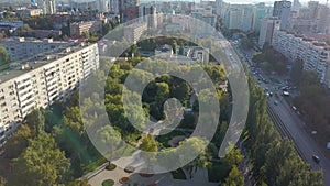 Aerial panorama of calm modern city in sunny evening in summer, lowering to park area