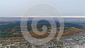 Aerial panorama city on lake bank against pine birch wood