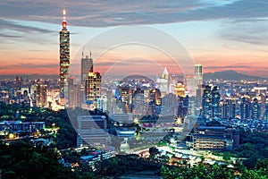 Aerial panorama of Downtown Taipei City with Taipei 101 Tower among skyscrapers under dramatic sunset sky