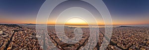 Aerial panorama drone shot of Barcelona with sunrise over sea horizon in Spain winter dawn