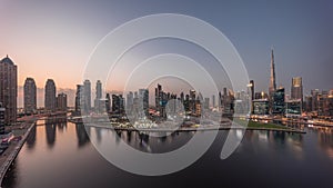 Aerial panorama of Dubai Business Bay and Downtown with the various skyscrapers and towers day to night timelapse