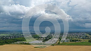 Aerial panorama. Golden agricultural field. Small town on the horizon.