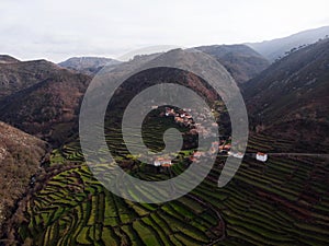 Aerial panorama of green agriculture farming terraces old remote rural mountain village town Porta Cova Portugal