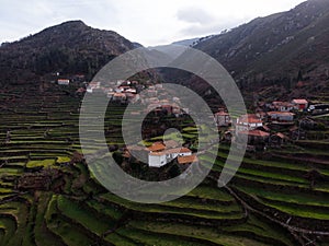 Aerial panorama of green agriculture farming terraces old remote rural mountain village town Porta Cova Portugal