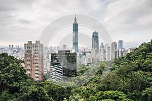 Aerial panorama over Downtown Taipei with Taipei 101 Skyscraper with trees on mountain in foreground from Xiangshan.