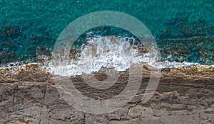 Aerial panorama of rocky coastline with breaking waves