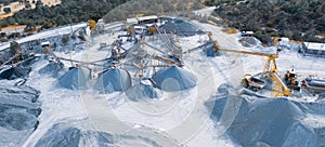 Aerial panorama of stone crushing and screening plant with piles of gravel and machinery