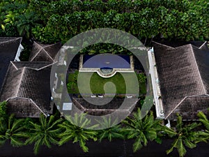 Aerial panorama of tropical island hotel resort blue swimming pool green jungle palm trees in Seminyak Bali Indonesia