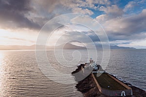 Aerial panorama view of the historic Fenit Lighthouse in Tralee Bay, beautiful clouds, sunset