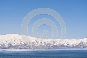 Aerial panorama view snow covered mountains. Snowy mountain ridge on winter sunrise. Stunning mountains range covered with snow