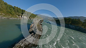 Aerial panorama view speed water flow mountain river cliff rocky texture island and walking bridge