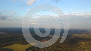 Aerial panorama of a vivid landscape with fields, forests and a beautiful bright blue sky with white clouds. Stock