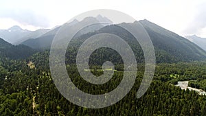 Aerial panorama: wild forest, green mountains and river. Beautiful natural forest background