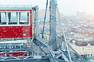 aerial panoramic citiscape view of Vienna from top of Prater amusement fair park ferris wheel during snowfall on cold snowy day.