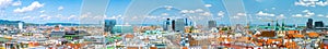 Aerial panoramic cityscape view of austrian capital city of Vienna. Summertime sunshine day, small cumulus clouds in the blue sky