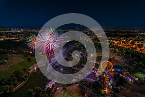 Aerial panoramic cityscape view with bright fireworks lights in night Munich.