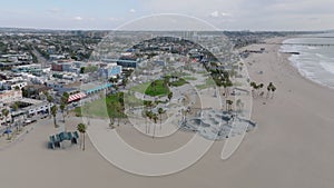 Aerial panoramic footage of ocean coast, wide Venice beach with skatepark and long boardwalk. Los Angeles, California