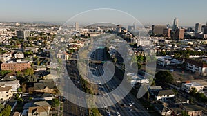 Aerial panoramic footage of vehicles driving on multilane thoroughfare leading through metropolis. Los Angeles