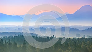 Aerial panoramic landscape of Alpine foggy foothills with morning sunrise over mountains