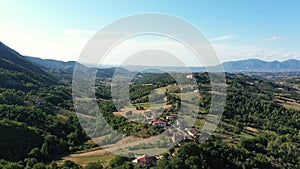 Aerial panoramic landscape of rural area with view on small village among picturesque mountains and forests. Impressive overlookin