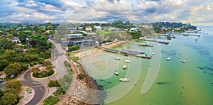 Aerial panoramic landscape of Sorrento suburb coastline with private piers and moored boats.