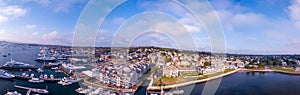 Aerial panoramic shot of the Newport Harbor in Rhode Island with ducked boats and a cloudscape