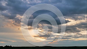 Aerial panoramic time lapse of epic sunset into the flying blue clouds over horizon in the twilight sky.  View from the top of the