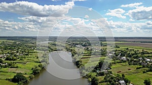 Aerial panoramic video above countryside lanscape with farmhouses on river banks.
