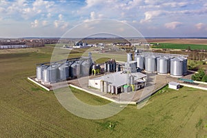 aerial panoramic view on agro-industrial complex with silos and grain drying line for drying cleaning and storage of cereal crops