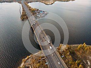 Aerial panoramic view of big river and transportation bridge over it with cars in autumn European city