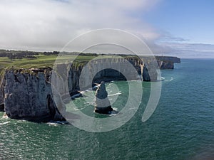 Aerial panoramic view on chalk cliffs and Porte d`Aval arch in Etretat, Normandy, France. Tourists destination