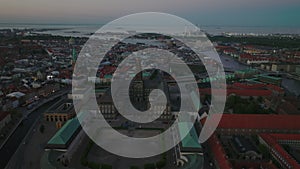 Aerial panoramic view of Christiansborg palace with tall tower. Evening shot of city at twilight. Copenhagen, Denmark